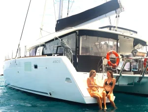 Soph and Liv, sitting on SV Whitsunday Freedom, a lagoon sailing catamaran, safely at anchor in the Whitsundays